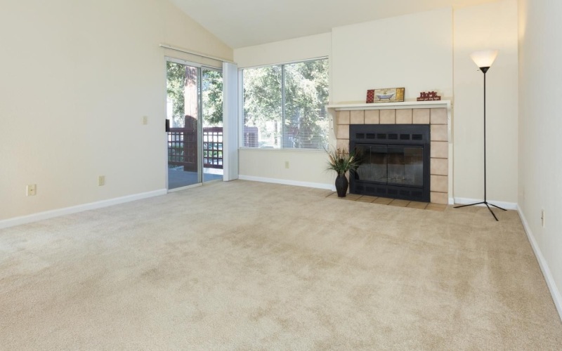A spacious living room with fireplace and balcony access