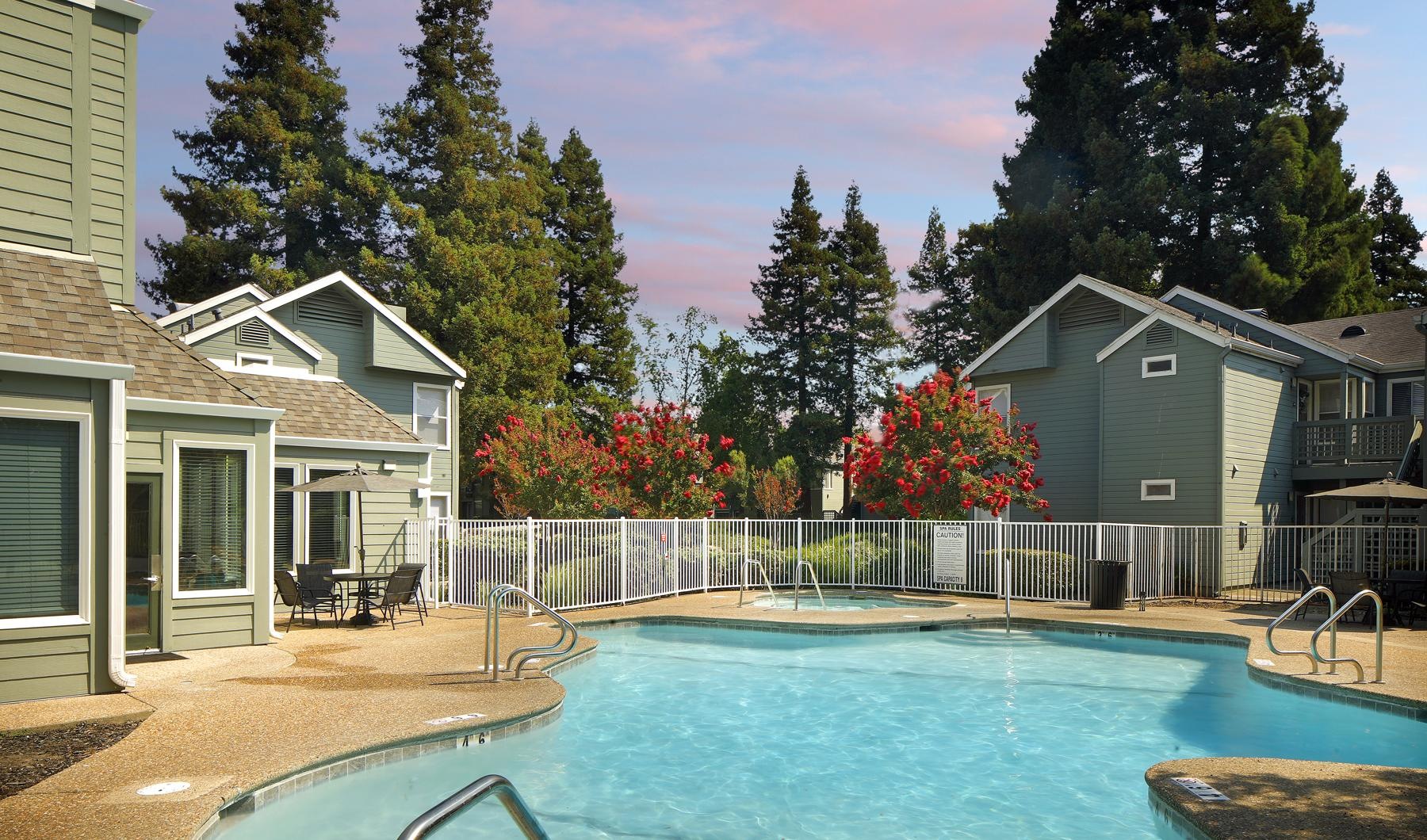 a pool next to a building with trees